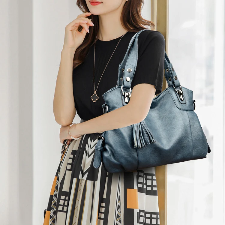 "Borsa a spalla elegante in pelle genuina; design robusto con chiusura zip e rivetti per stile e praticità."