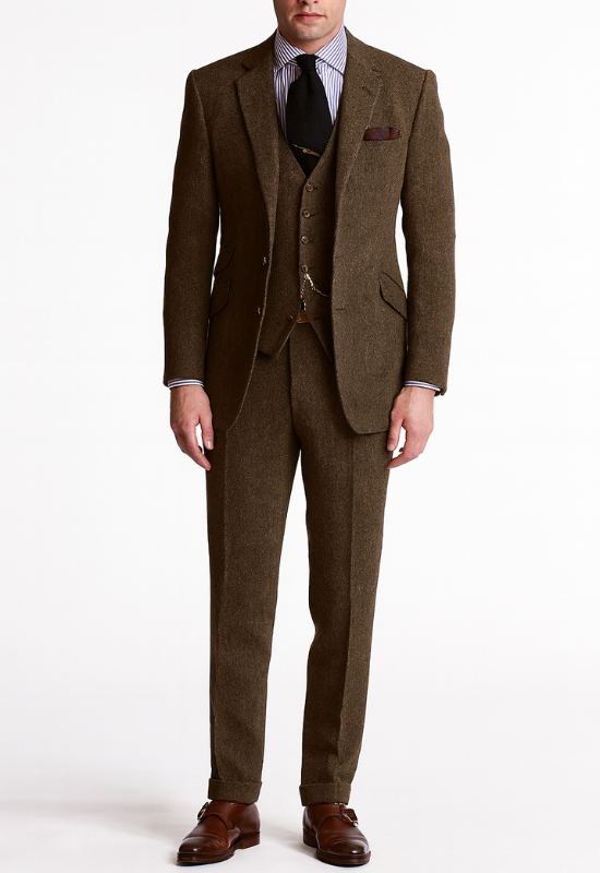 "Completo uomo elegante tre pezzi in tweed marrone tabacco, giacca monopetto, gilet abbottonato e pantaloni affusolati."
