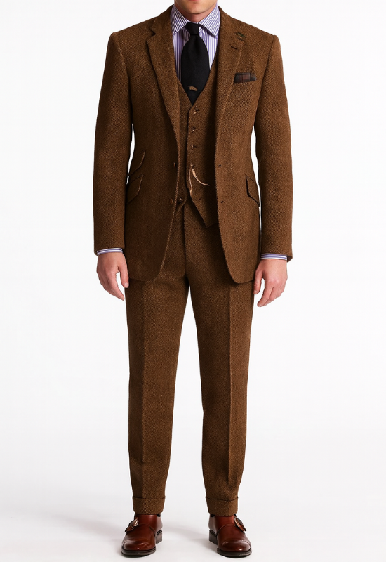 "Completo uomo elegante tre pezzi in tweed marrone tabacco, giacca monopetto, gilet abbottonato e pantaloni affusolati."