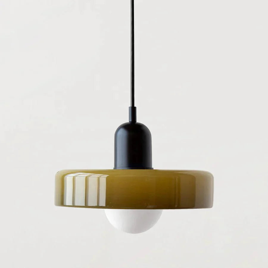 "Lampada a sospensione in vetro trasparente con design minimalista, emette luce soffusa, ideale per interni eleganti."