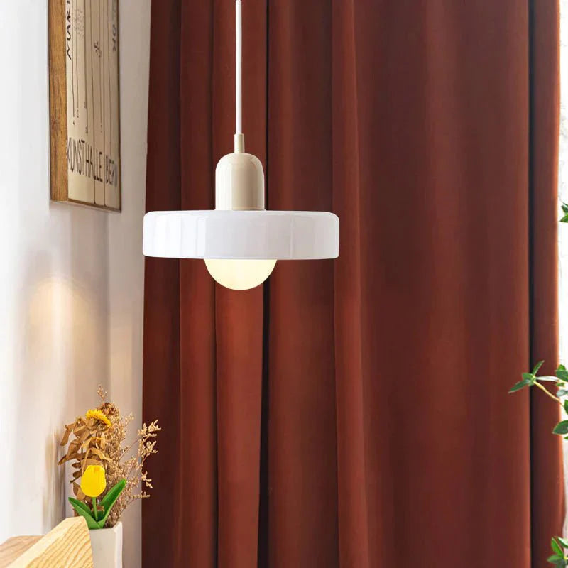 "Lampada a sospensione in vetro trasparente con design minimalista, emette luce soffusa, ideale per interni eleganti."