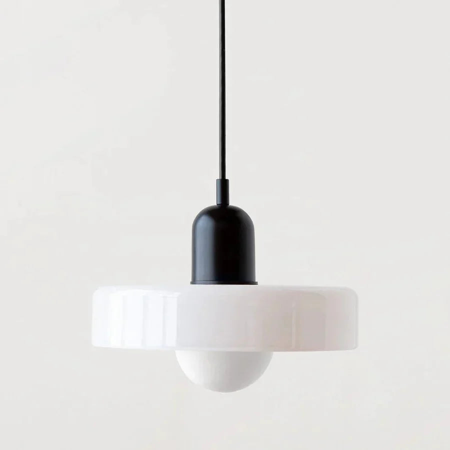 "Lampada a sospensione in vetro trasparente con design minimalista, emette luce soffusa, ideale per interni eleganti."