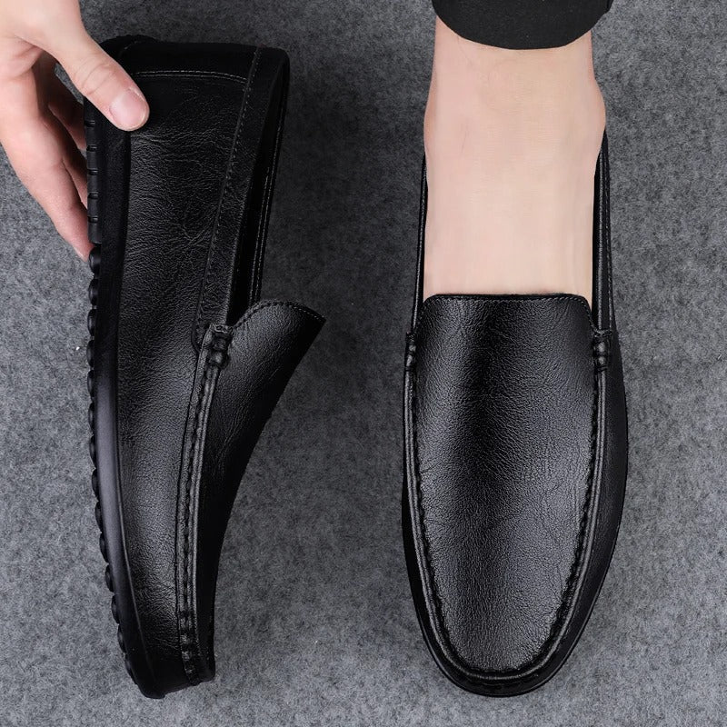 "Mocassini eleganti da uomo in pelle nera con design slip-on e dettagli artigianali, perfetti per look formali o casual."