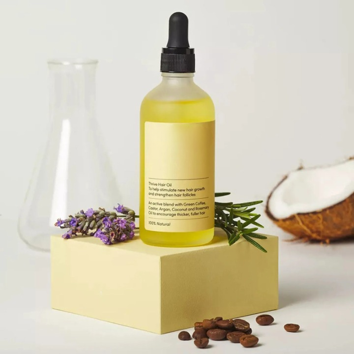 "Olio crescita capelli naturale, siero vegano, flacone trasparente con liquido dorato e tappo bianco."