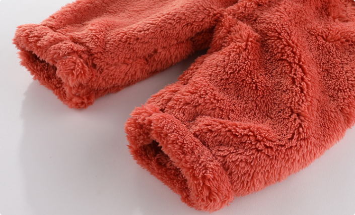 "Tutina neonato in pile morbido beige con cappuccio, chiusura a bottone per calore e comfort ideale in inverno."