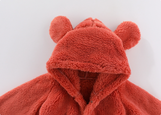 "Tutina neonato in pile morbido beige con cappuccio, chiusura a bottone per calore e comfort ideale in inverno."