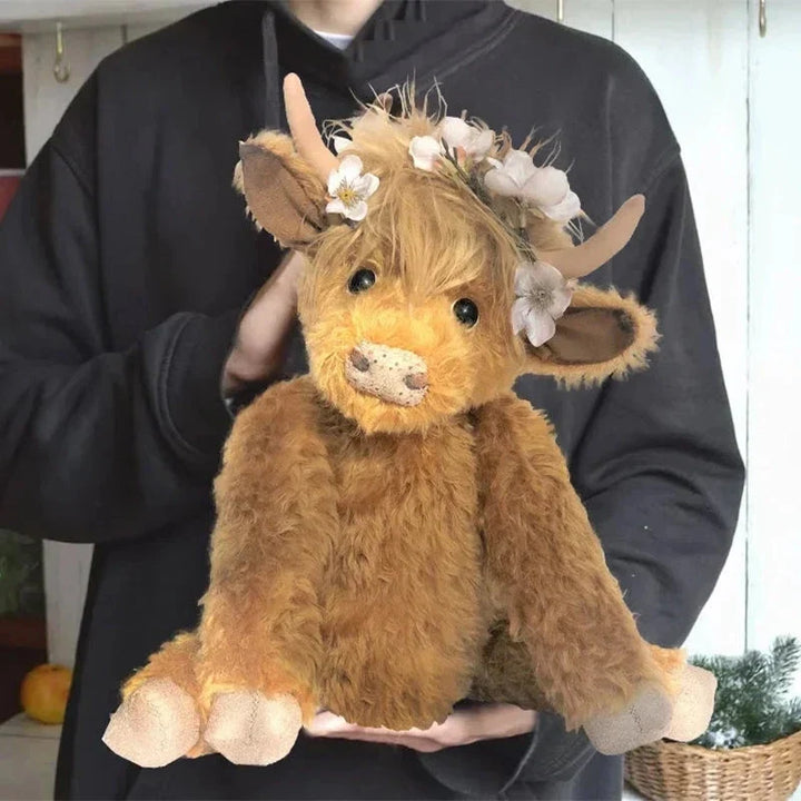 Soft alpaca fiber highland cow desk buddy, featuring a charming handcrafted floral crown.