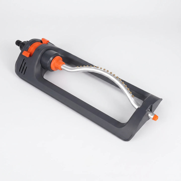 Green oscillating lawn sprinkler providing automatic, even watering for a healthy, lush garden and yard.