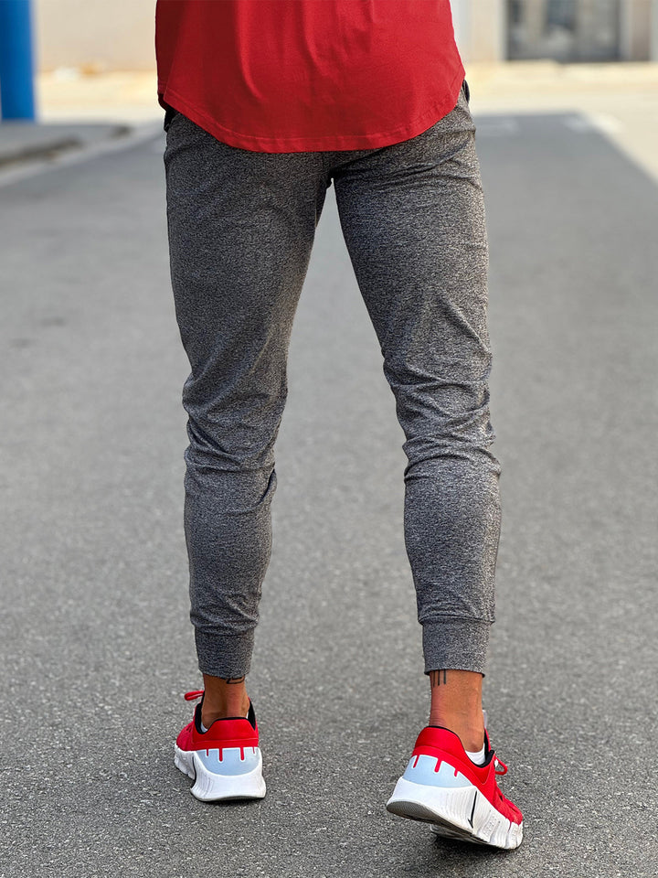 Men's performance stretch joggers, dark grey, on a runner mid-stride.