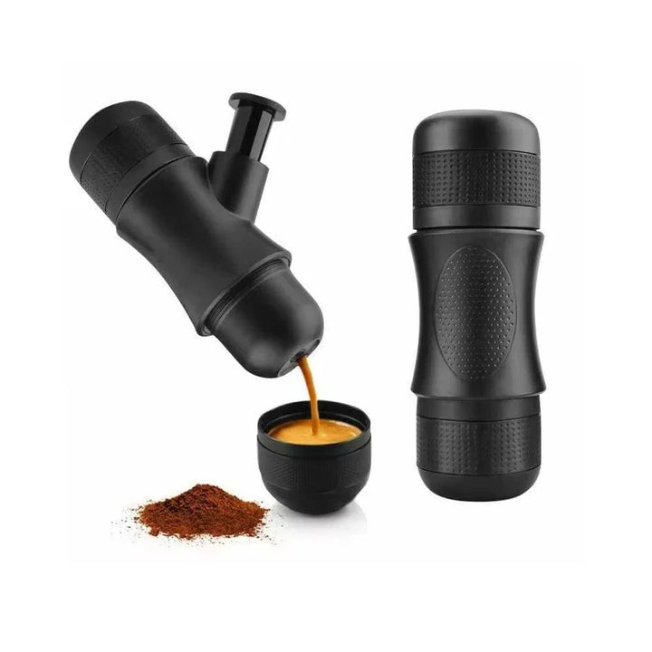 Black portable manual espresso maker, compact for travel & camping, beside a travel mug.