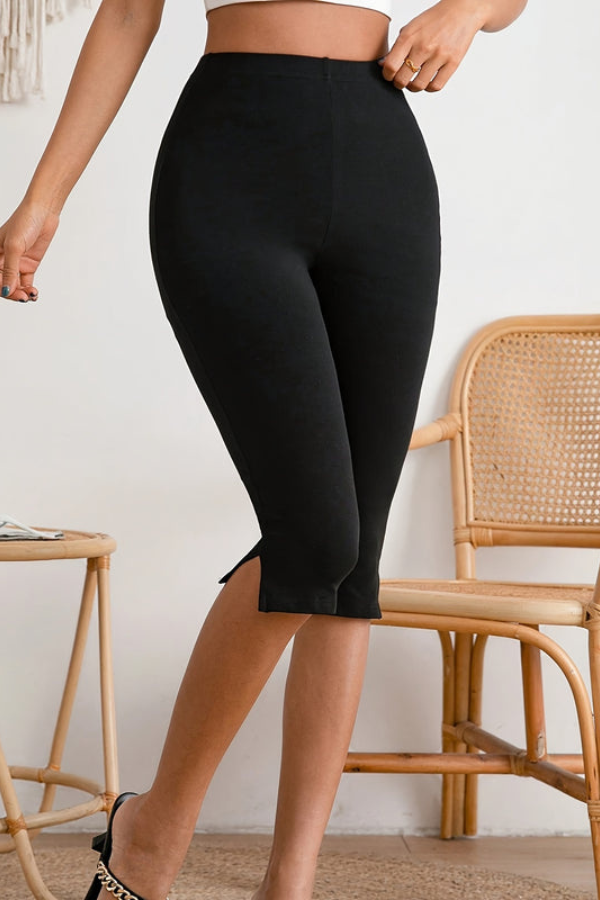 Woman wearing black slim-fit stretch cropped pants, showcasing their comfortable fit and flattering silhouette.