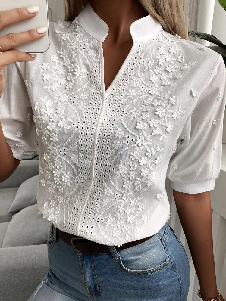 "Blusa donna bianca con ricamo floreale e scollo a V, design elegante e sofisticato per ogni occasione."