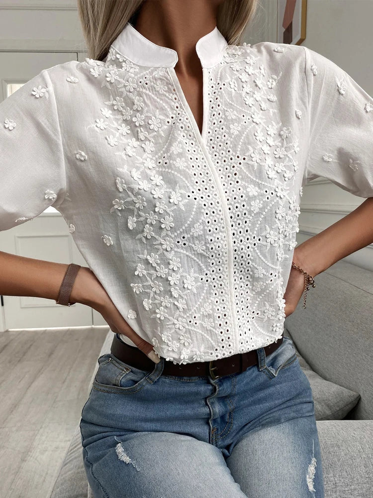 "Blusa donna bianca con ricamo floreale e scollo a V, design elegante e sofisticato per ogni occasione."