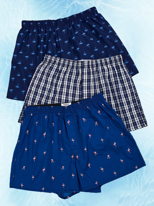"Boxer uomo blu in cotone traspirante, fascia elastica per comfort e stile, fondo blu con stampe assortite, vista frontale."