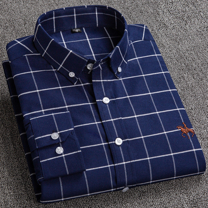 "Camicia uomo a quadri in cotone naturale traspirante, resistente e versatile, sfondo chiaro, dettagli eleganti e moderni."