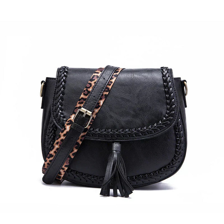Fashion-forward black women's saddle bag, with a trendy tassel. Versatile shoulder accessory.