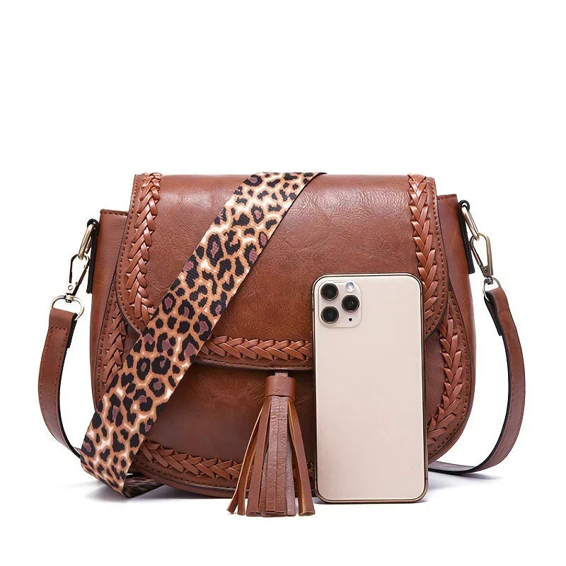 Trendy white women's saddle bag with playful tassel. A stylish crossbody and fashion accessory.