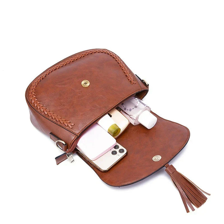 Classic brown women's saddle bag, featuring an elegant tassel detail. Great for everyday wear.