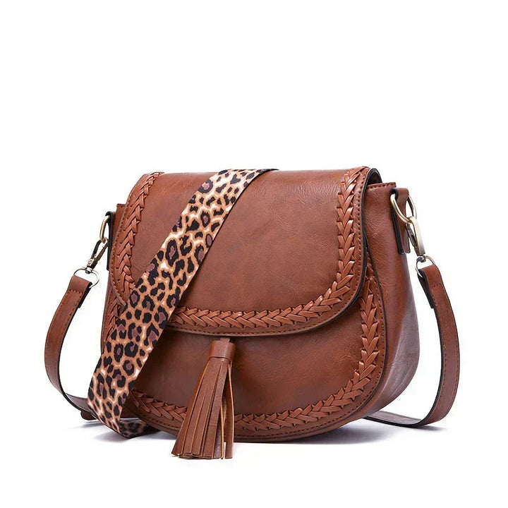 Sophisticated black women's saddle bag with chic tassel. A versatile fashion crossbody bag.