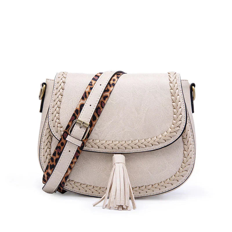 Modern white women's saddle bag with stylish tassel. An elegant shoulder bag for any occasion.