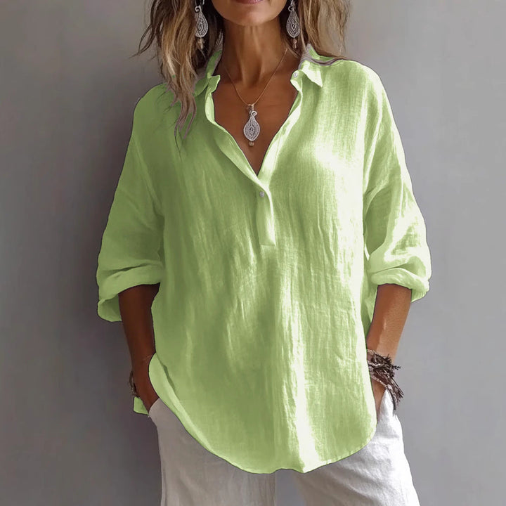 Stylish women's button-up top, featuring elegant flowing sleeves & a relaxed fit, ideal for warm weather.