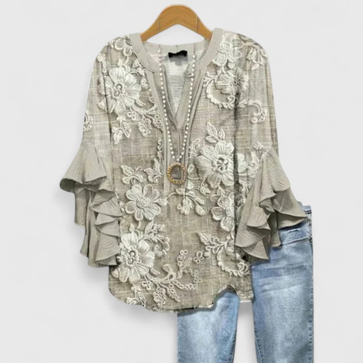 Elegant ladies' floral blouse featuring delicate ruffled sleeves, ideal for casual or workwear occasions.