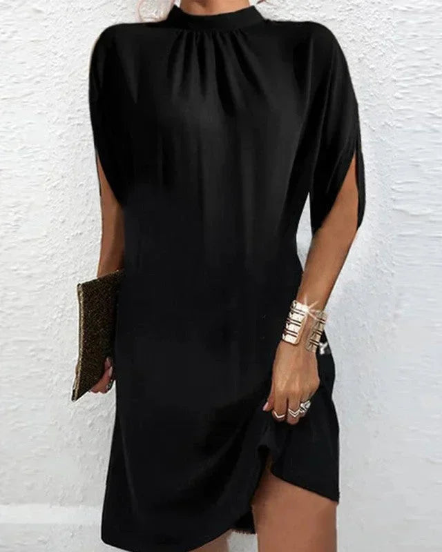 Elegant women's party mini dress with a mock neck, flowing cape sleeves, and a trendy asymmetric hem.