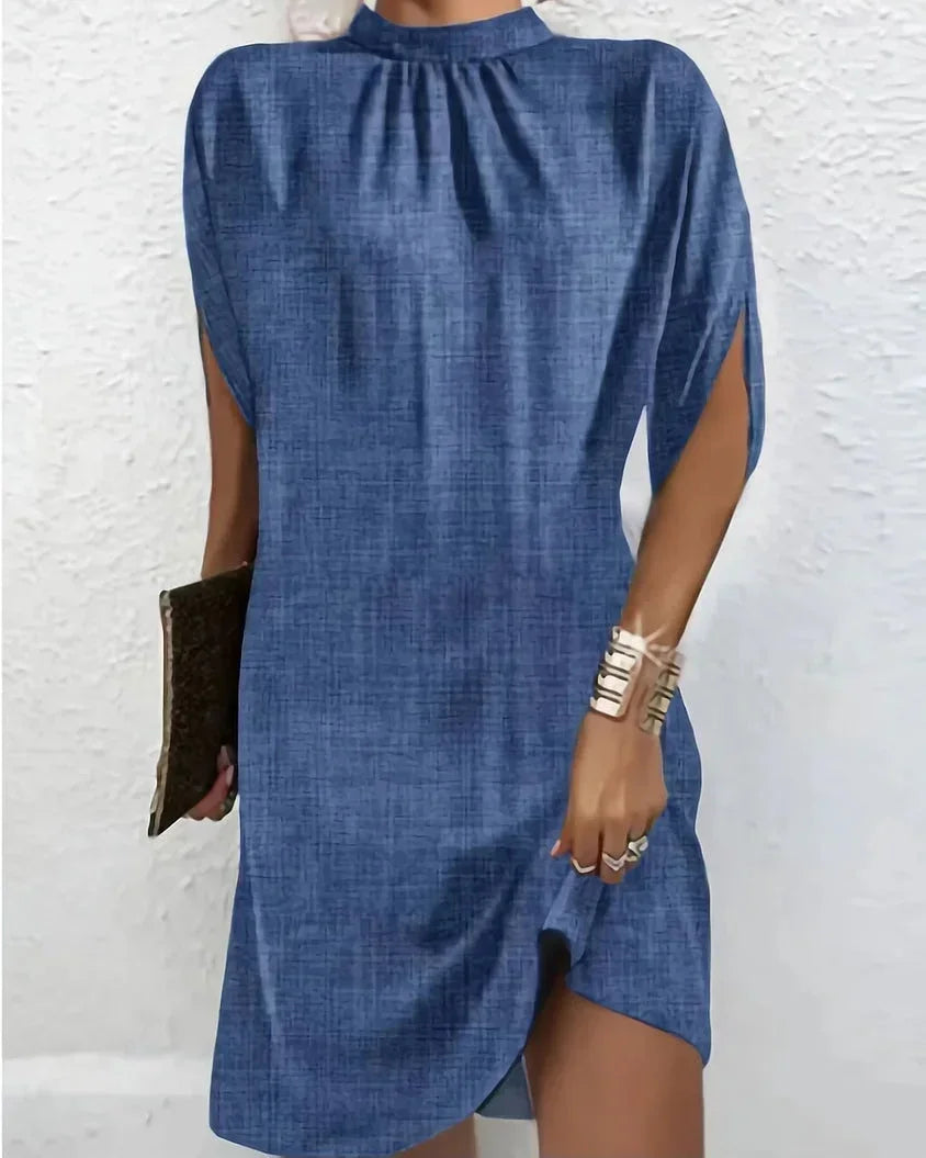 Women's mini dress showcasing a mock neck, unique cape sleeves, and a modern asymmetric hem.