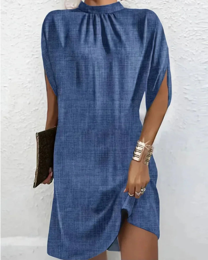Women's mini dress showcasing a mock neck, unique cape sleeves, and a modern asymmetric hem.