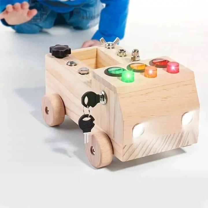Close-up of a children's wooden activity board, showing colorful latches, a spinning gear, and bead maze for fine motor practice.
