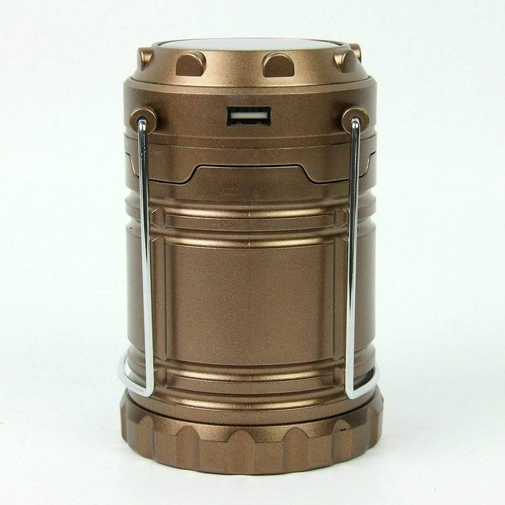 Collapsible LED camping lantern, fully extended, providing ambient light for an evening camp.