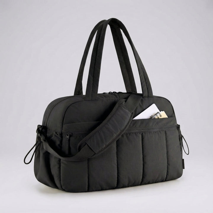 Aerelle compact lightweight duffel bag, ideal for travel. Shown with organized essentials, perfect as a carry-on.