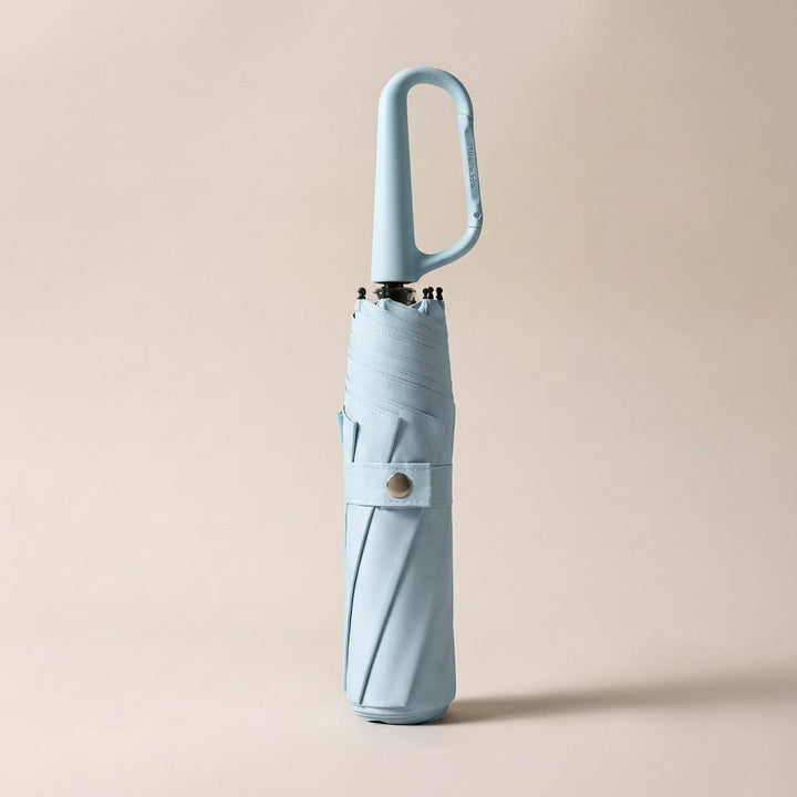 Portable clip-on umbrella, ideal for bags, providing quick and compact rain or sun protection on the go.