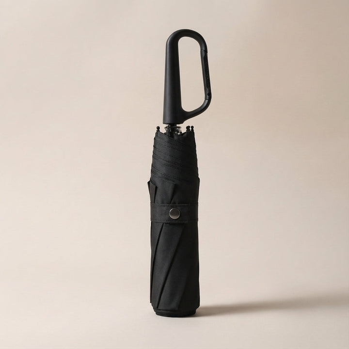 Foldable travel umbrella with a strong clip, ideal for hands-free carry and quick access in rain or sun.