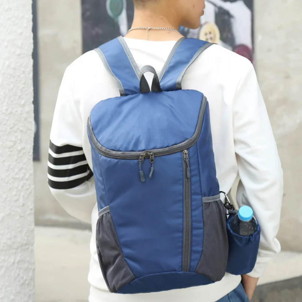 Compact backpack displayed open, showing internal organization for travel and daily items