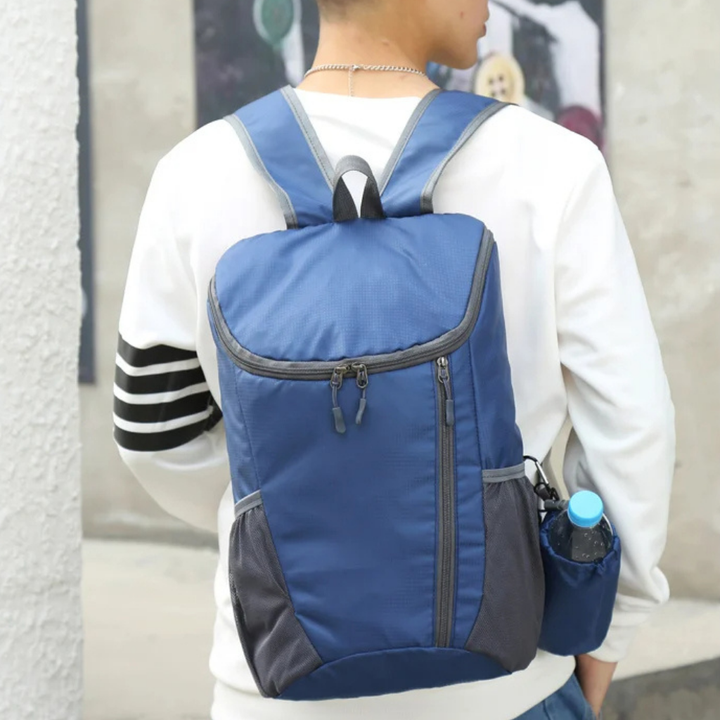 Compact backpack displayed open, showing internal organization for travel and daily items