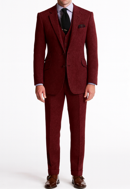 "Completo uomo elegante tre pezzi in tweed marrone tabacco, giacca monopetto, gilet abbottonato e pantaloni affusolati."