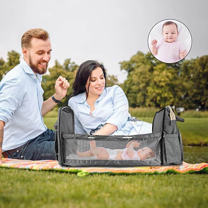 Open foldable baby bassinet and changing station, part of the convertible travel diaper backpack.