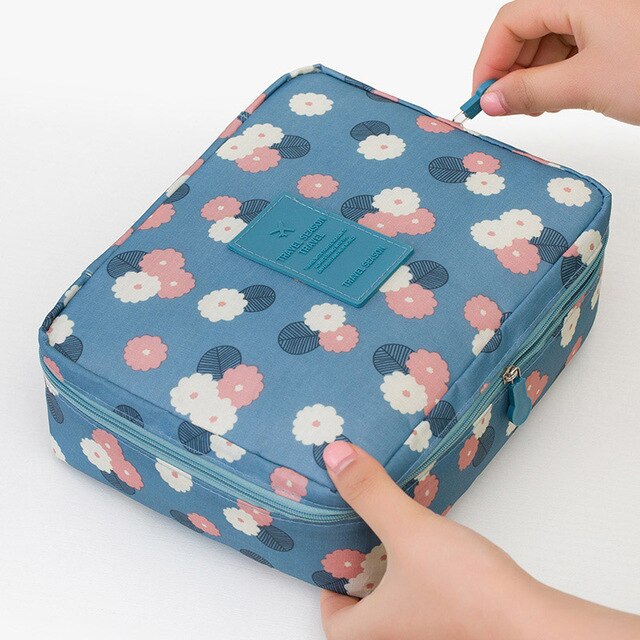 Women's dark blue floral waterproof makeup travel organizer, a compact solution for beauty essentials.