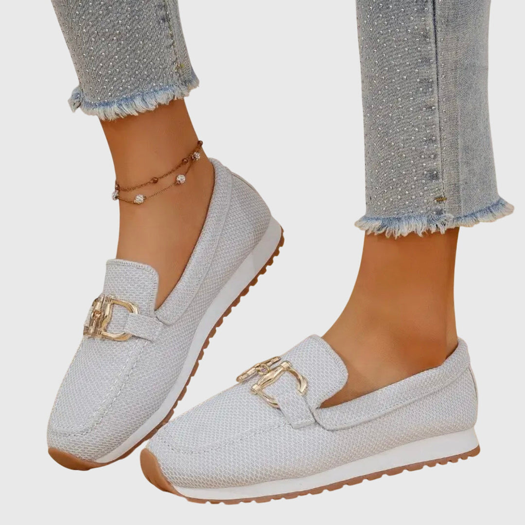 Close-up of dusty blue women's horsebit loafers. Elegant slip-on flats with classic horsebit detail.