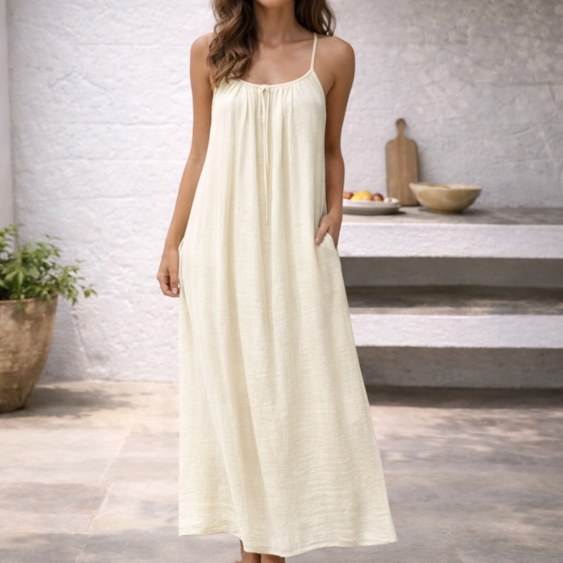Ladies' casual maxi dress with spaghetti straps, featuring a flowy silhouette & handy pockets.