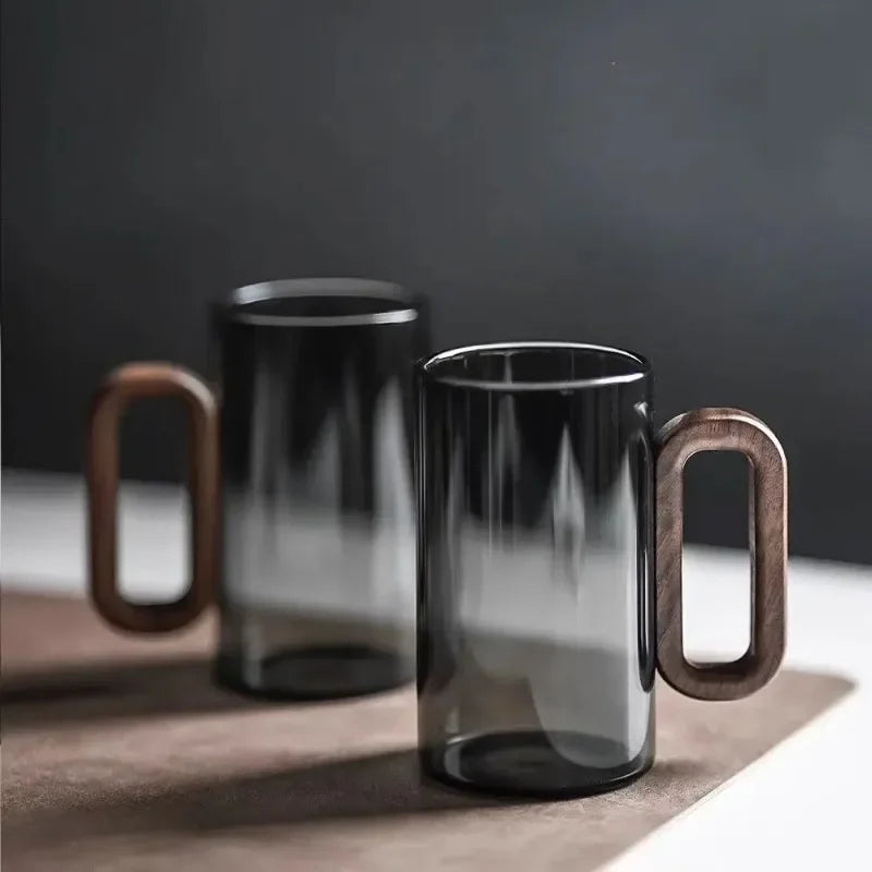 Elegant black borosilicate drinking glass with a sleek walnut handle, perfect for beverages, kitchenware & home decor.
