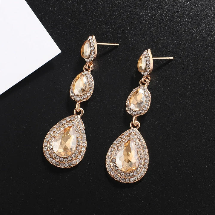 Shimmering women's emerald cascade drop earrings, elegant green stainless steel vibrant accessory.
