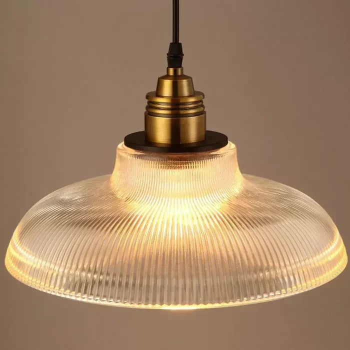 Transparent glass pendant lamp, elegant modern light fixture providing warm ambient lighting for living spaces.