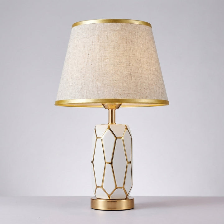 Versatile ceramic desk or table lamp with a cylindrical fabric shade, offering warm ambient light.
