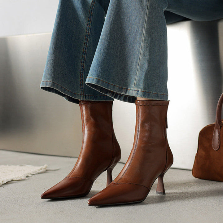 Women's sleek black pointed-toe heeled boots, exuding confidence and elegance for any occasion.