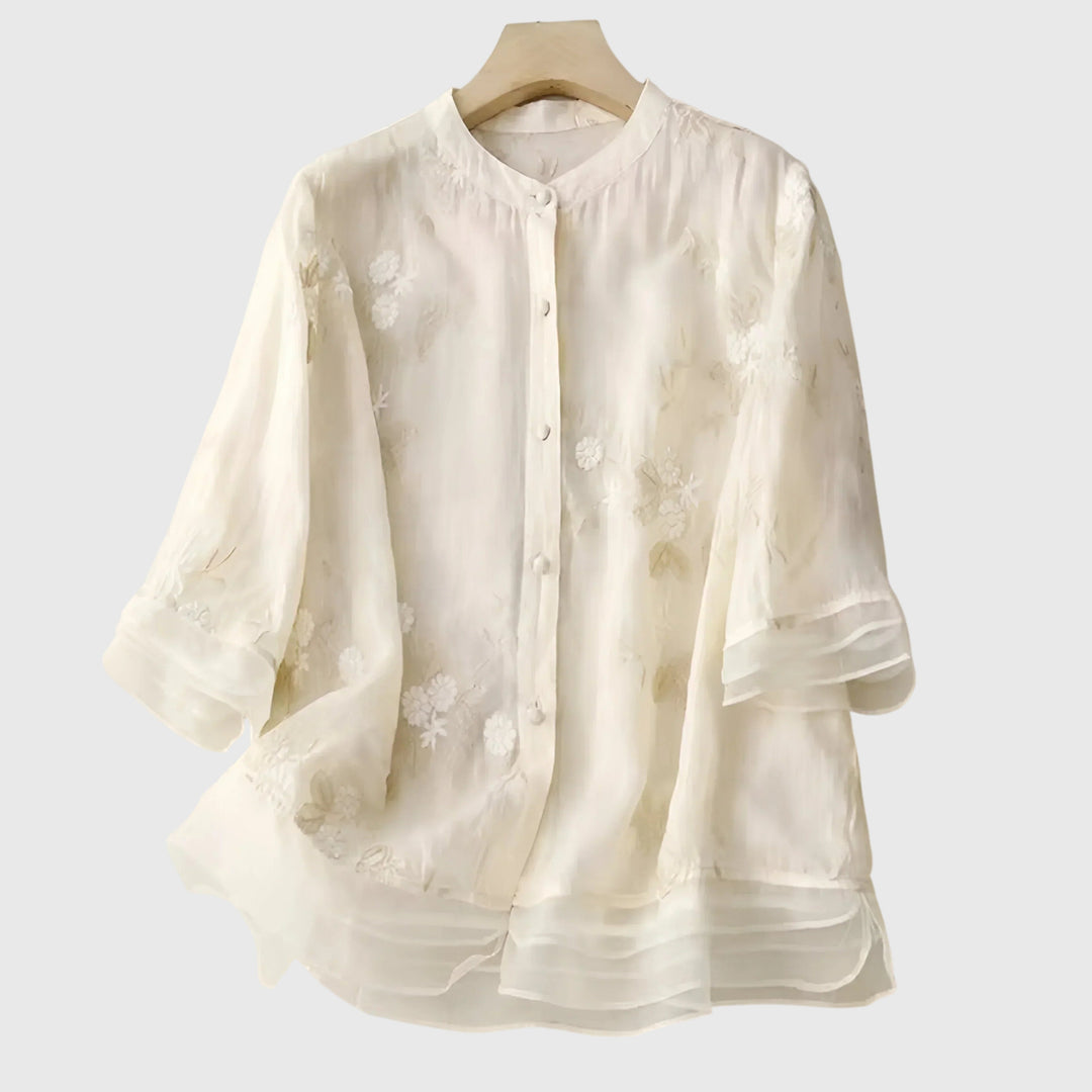 Elegant women's blouse with delicate floral embroidery, perfect for spring/summer fashion.