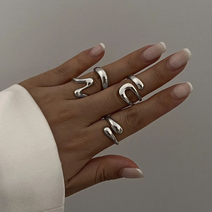 Silver-tone women's sculptural ring set with fluid design, perfect elegant jewelry.