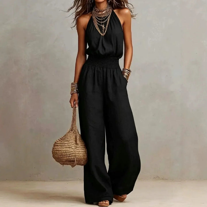 Flowy women's wide leg jumpsuit, halter neck, smocked waist. Ideal for casual summer outings & vacation comfort.