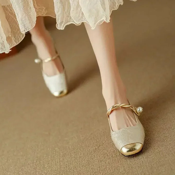 Low-heel Women's Mary Jane flats for comfort and elegance, styled with a unique pearl strap & metallic toe.